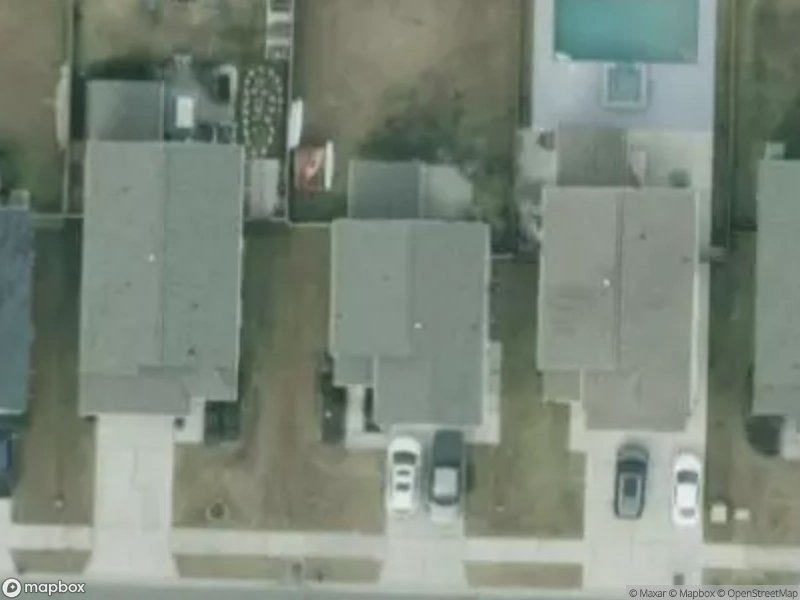 Aerial view of residential houses with driveways and a swimming pool in the backyard.