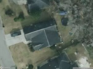 Aerial view of residential area with several houses and a driveway.