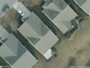 Aerial view of residential houses with driveways and grassy areas.
