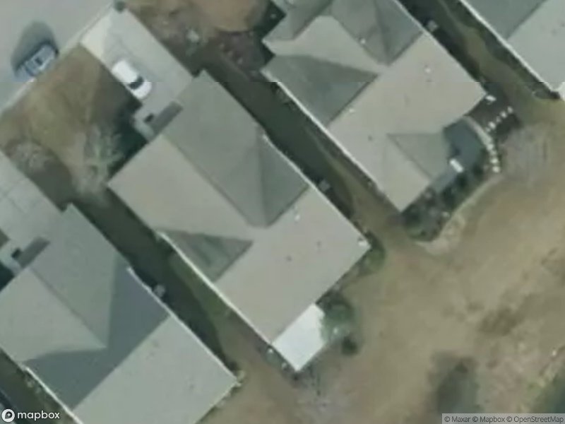Aerial view of residential houses with driveways and grassy areas.