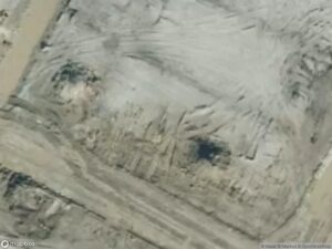 Aerial view of a barren landscape with dirt paths and uneven terrain.