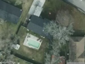 Aerial view of residential area with several houses and a swimming pool in a backyard.