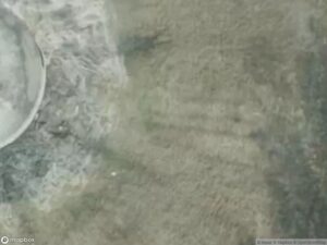 Aerial view of a landscape with varying textures and colors, possibly water and land.