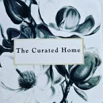 Floral design background with the text "The Curated Home" prominently displayed.