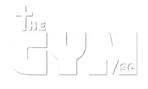 White logo featuring "THE GYM" with a cross symbol above the text.