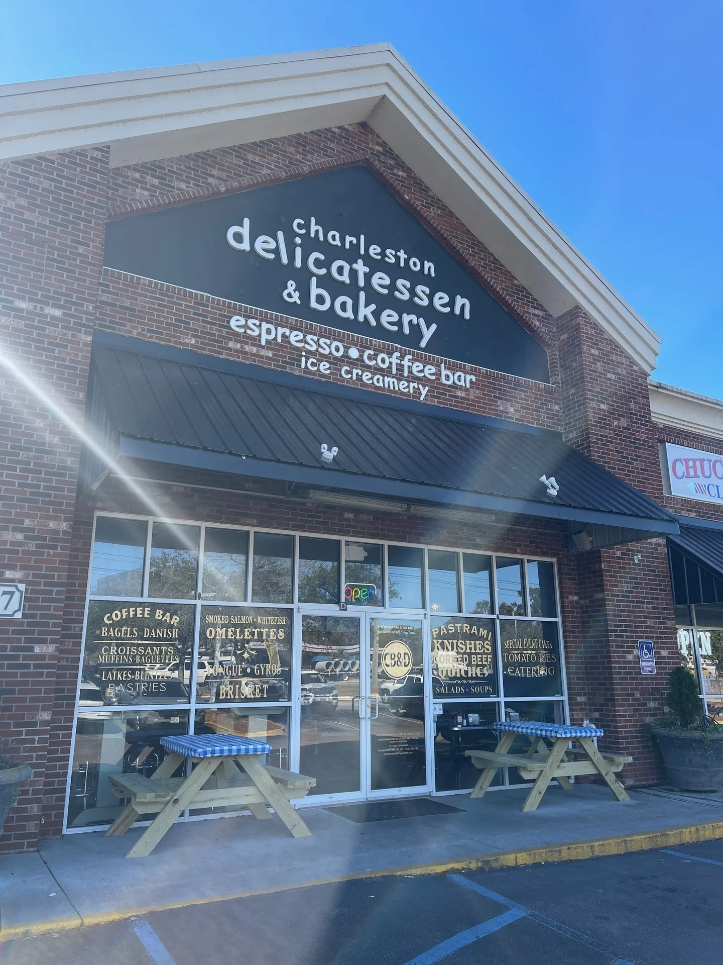 Charleston delicatessen and bakery storefront with outdoor seating and menu signage.