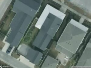 Aerial view of residential houses with gray roofs and surrounding driveways.