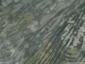 Satellite image showing textured rock formations with varying shades of gray and green.