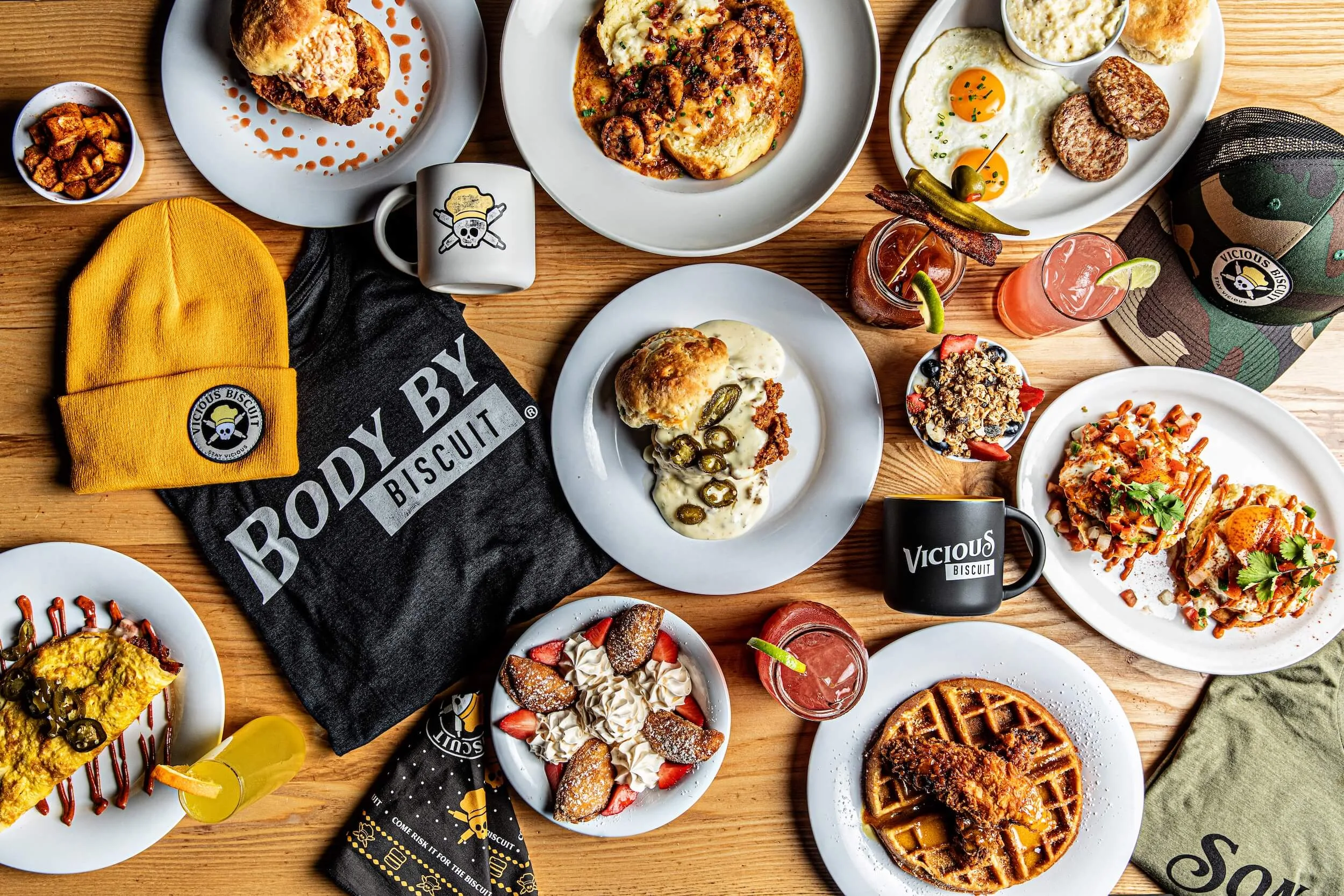 A variety of breakfast dishes, drinks, and merchandise on a wooden table.