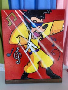A cartoon character in a yellow outfit dances energetically against a red background, surrounded by musical notes.