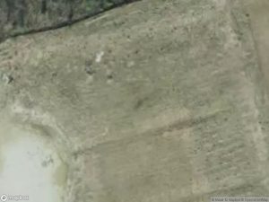 Aerial view of a barren landscape with patches of vegetation and soil.