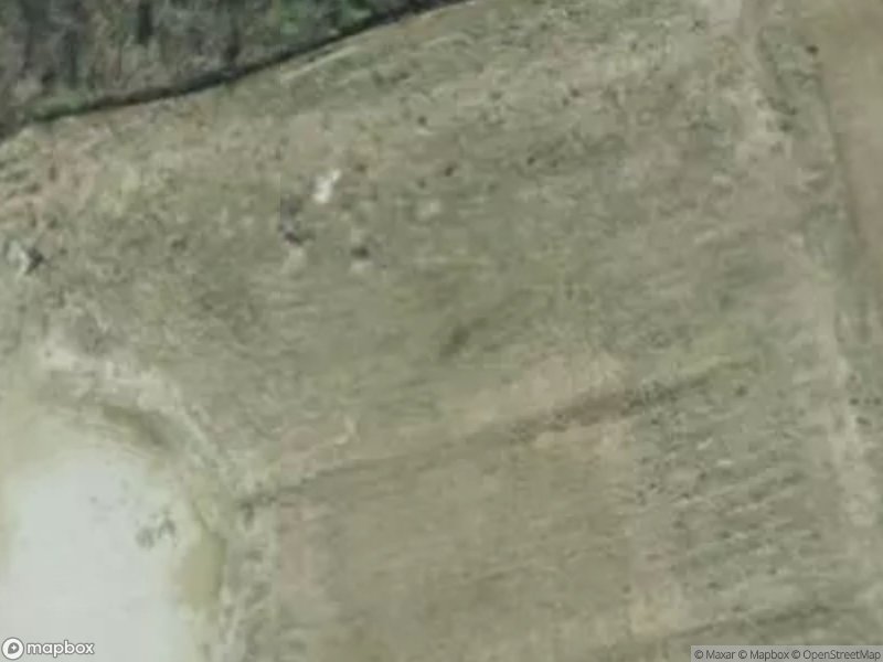 Aerial view of a barren landscape with patches of vegetation and soil.