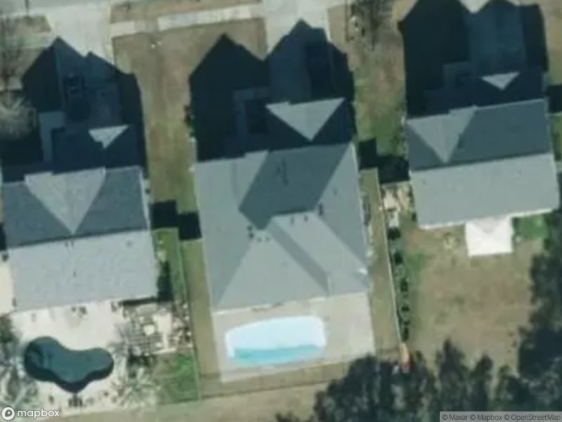 Aerial view of several houses with a swimming pool in the backyard.