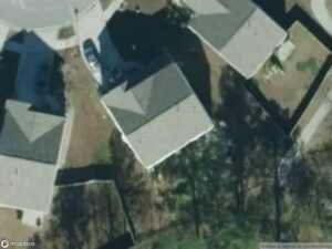 Aerial view of residential area with several houses and a parked car.