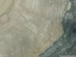 Aerial view of a rugged terrain with distinct geological patterns and varying colors.