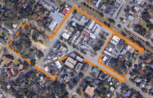Aerial view of a neighborhood with outlined boundaries, showing buildings and streets.