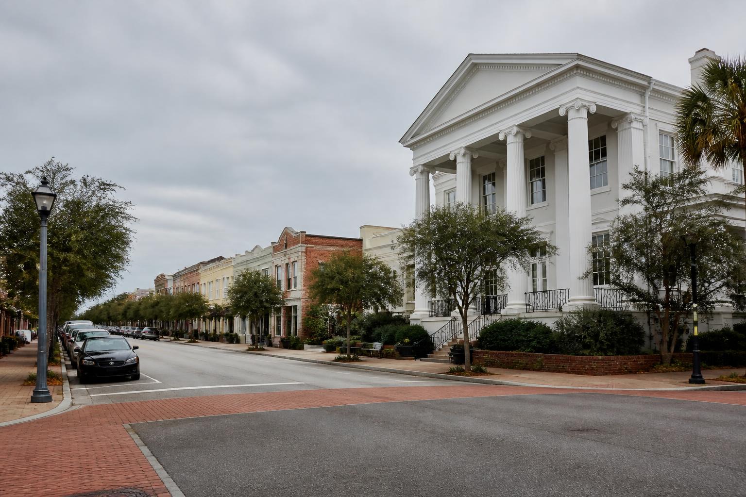 Historic buildings line a quiet street in Summerville, SC, under a cloudy sky.